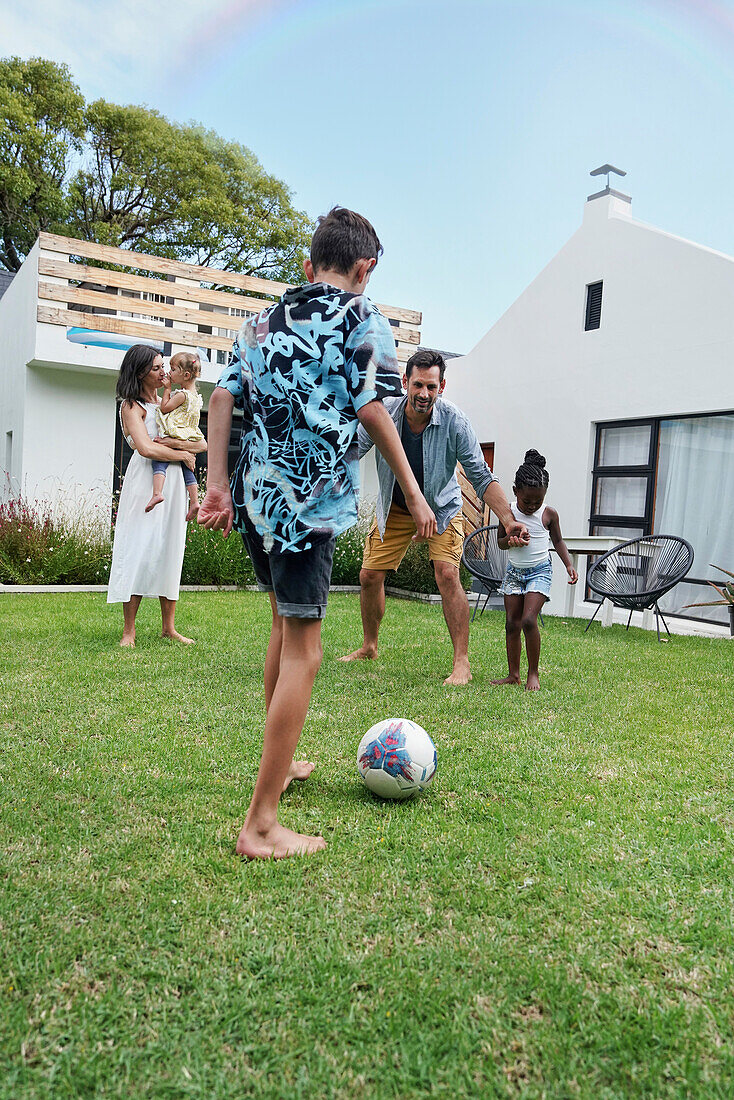 Parents with children playing in backyard