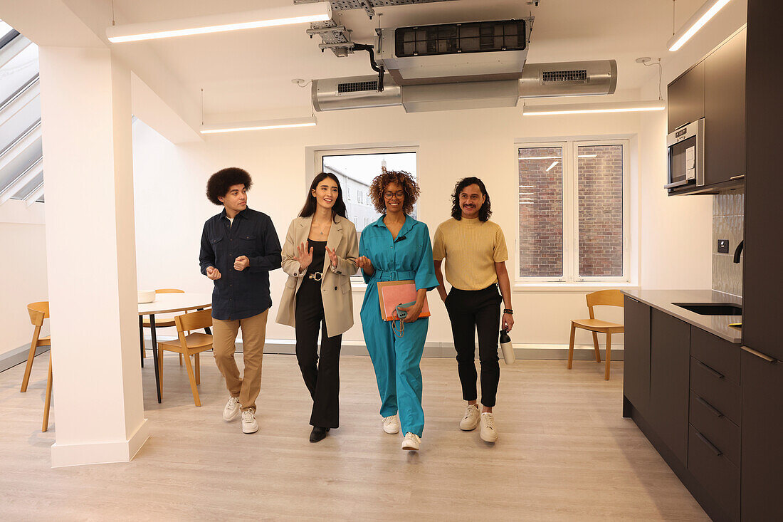 Smiling colleagues walking in modern creative studio