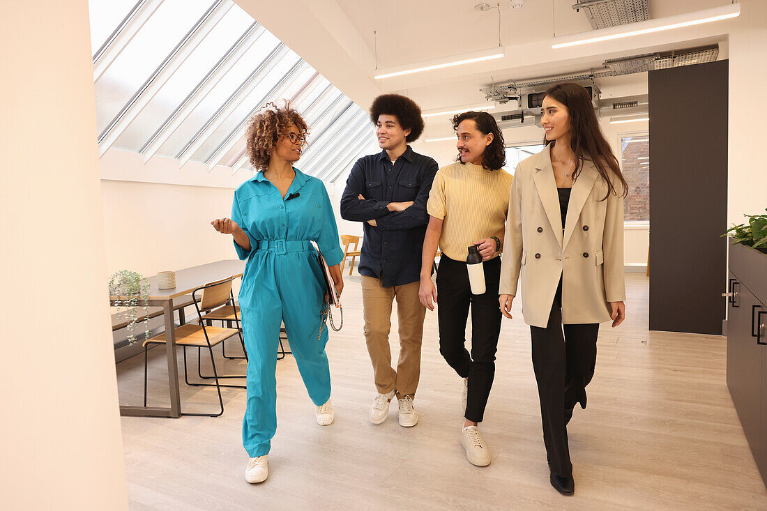 Smiling colleagues walking in modern creative studio