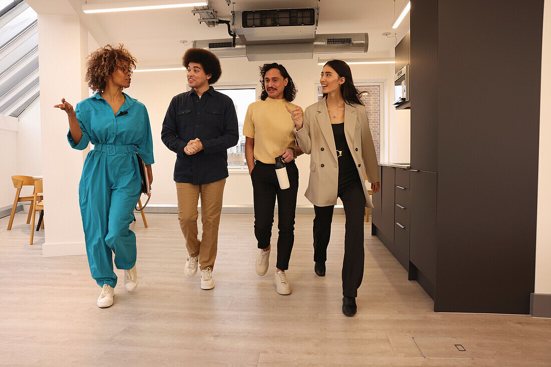 Smiling colleagues walking in modern creative studio