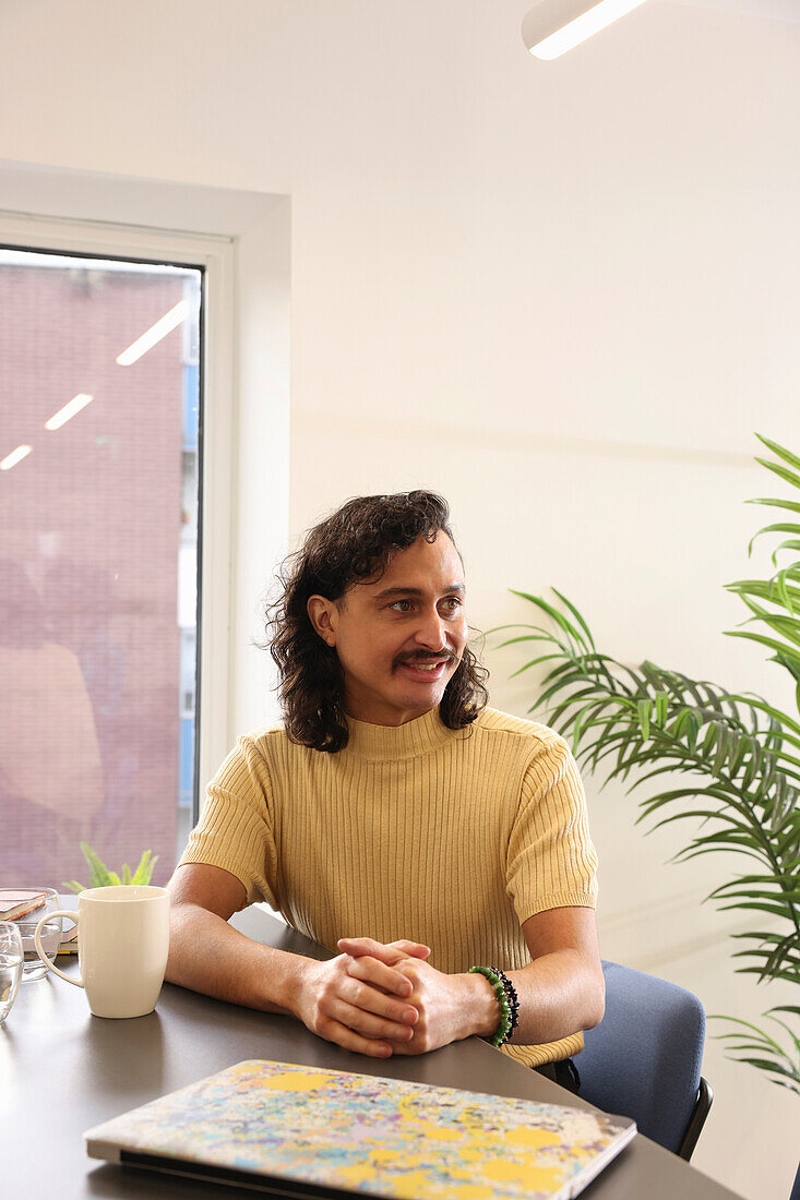 Smiling man sitting in creative office