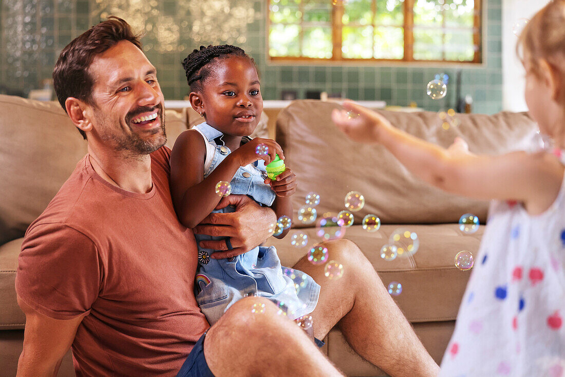 Father with daughters playing with bubbles