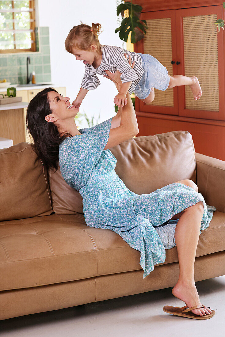 Woman playing with daughter at home