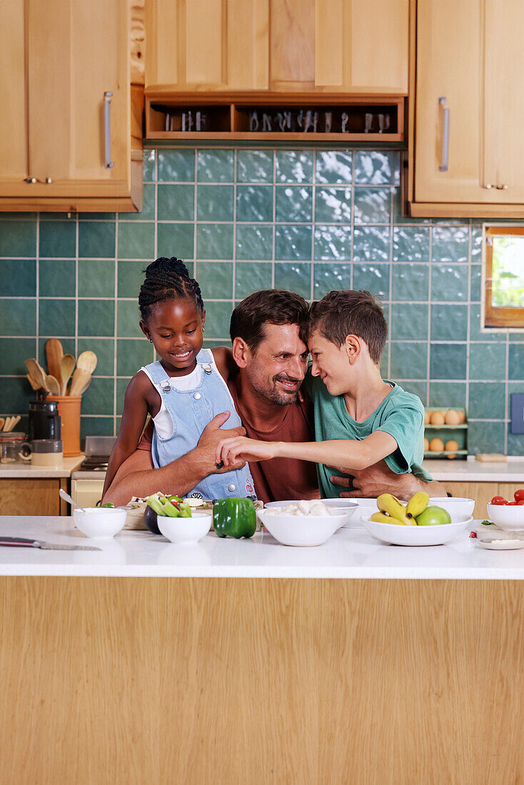 Father embracing children in kitchen