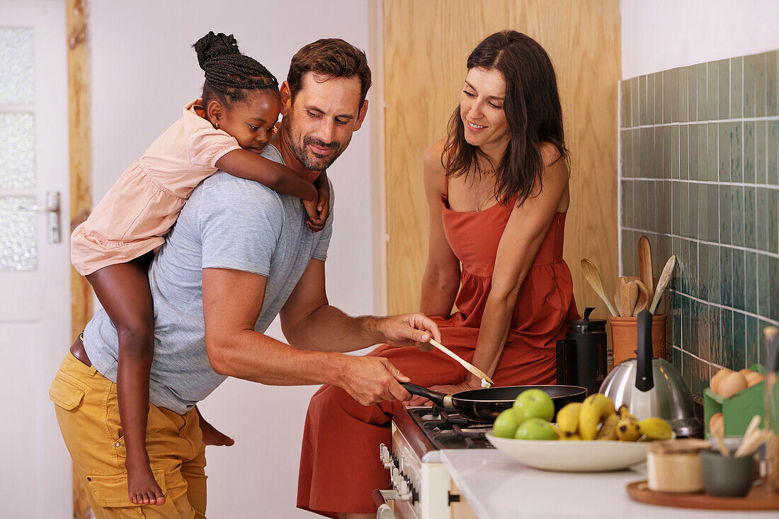 Parents with daughter cooking in kitchen