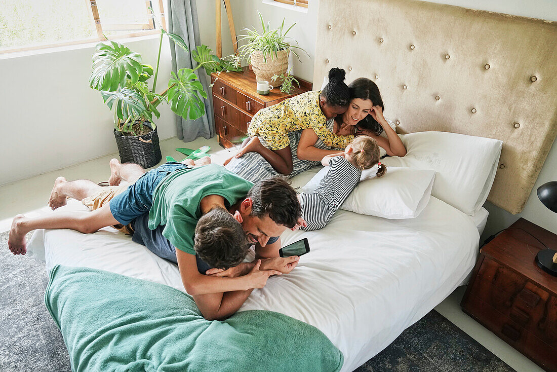 Parents with children relaxing on bed