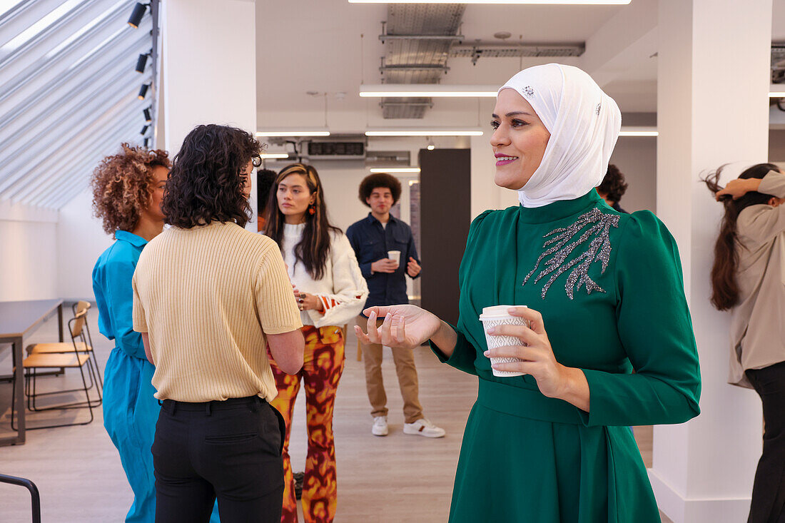 Employee holding coffee during team meeting