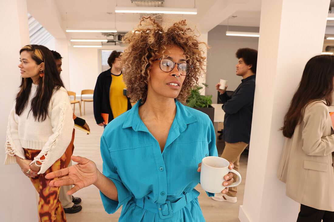 Employee holding coffee during team meeting