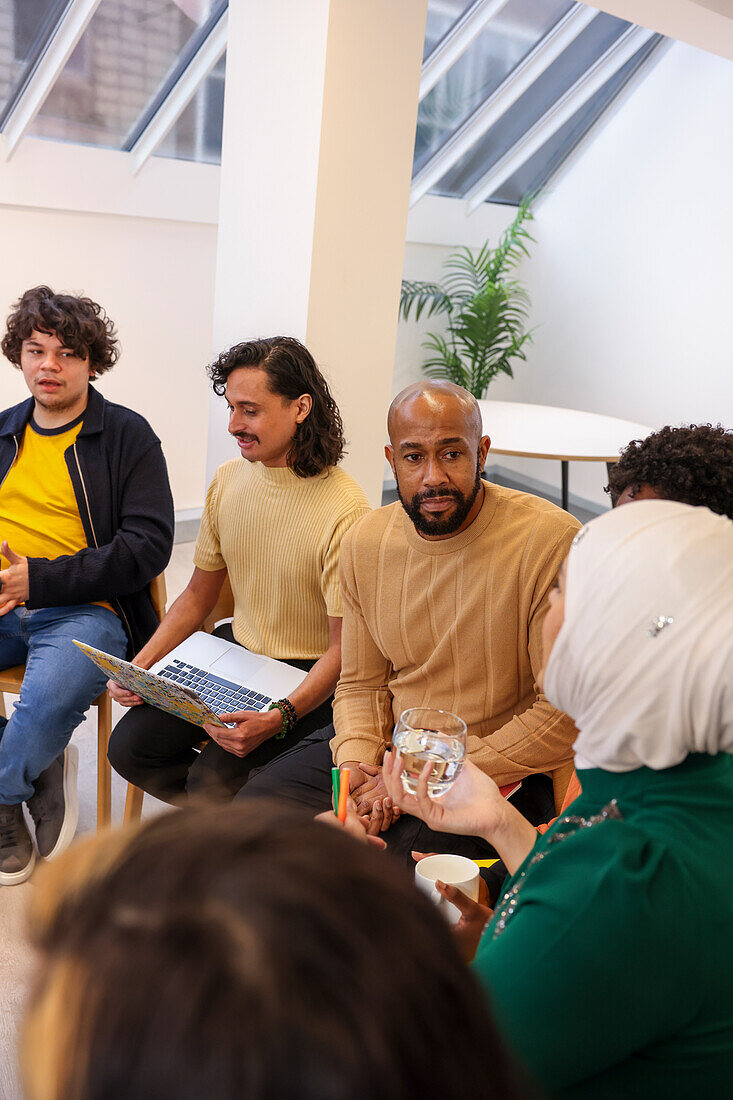 Employees in discussion at team meeting