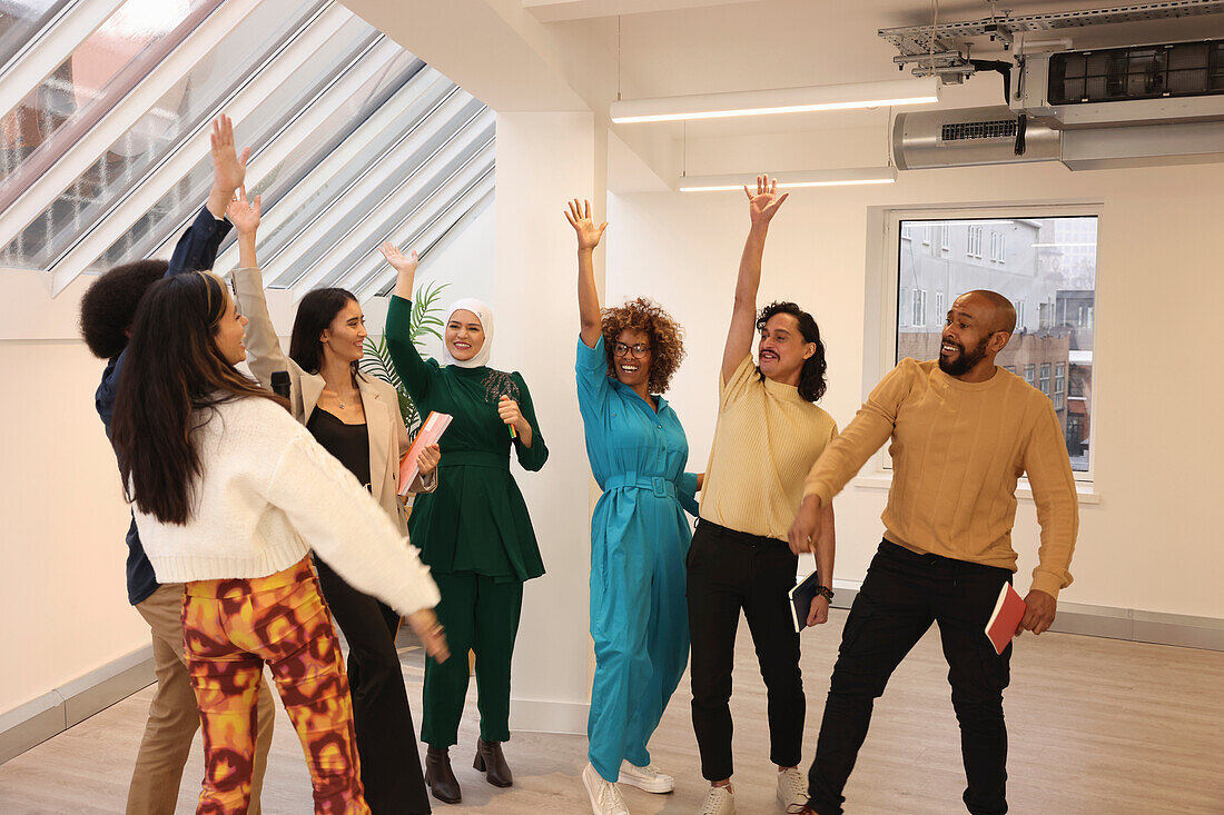 Smiling creative workers cheering in office