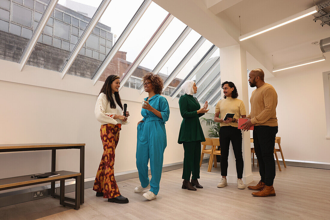 Smiling creative workers talking in office