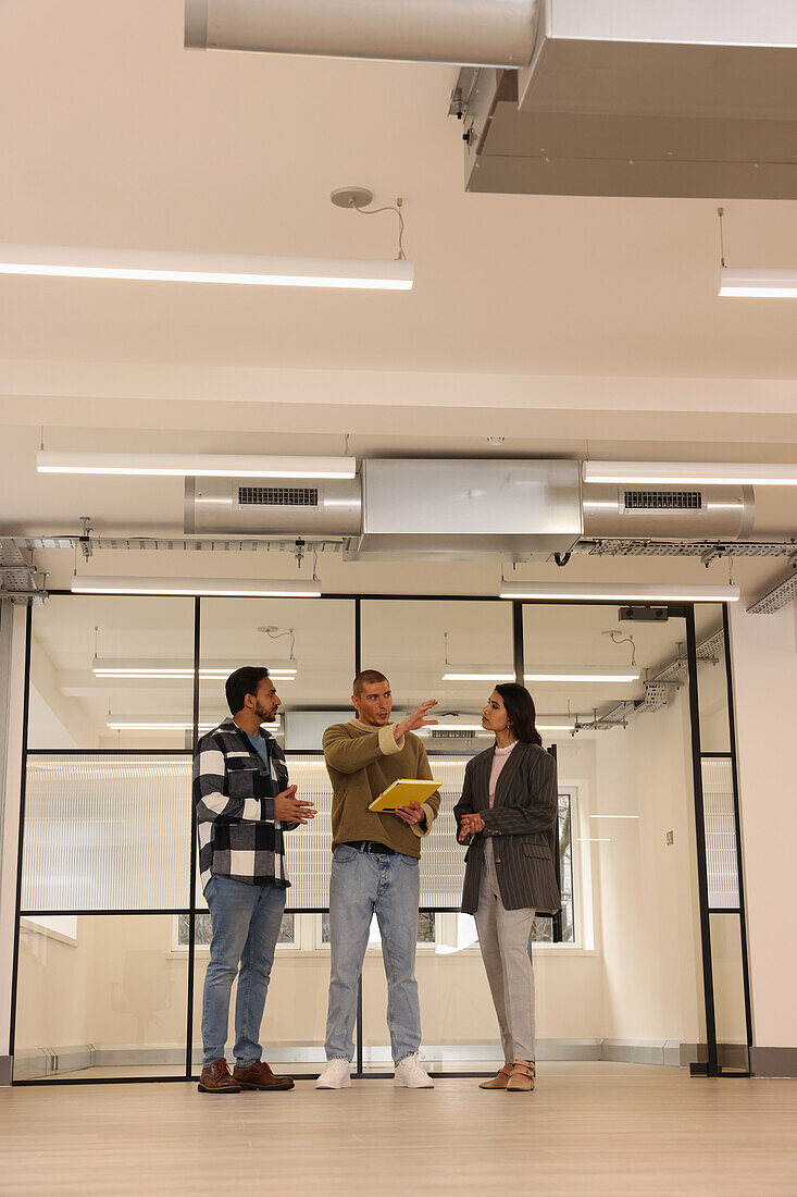 Coworkers talking in empty office