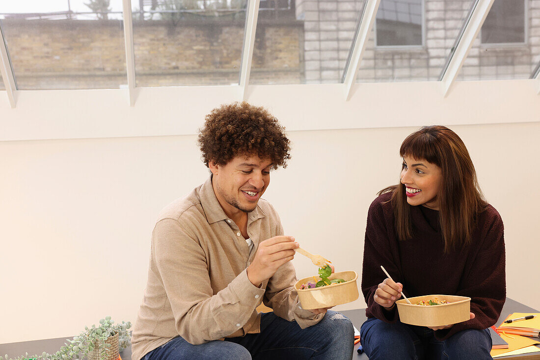 Coworkers eating salads in office