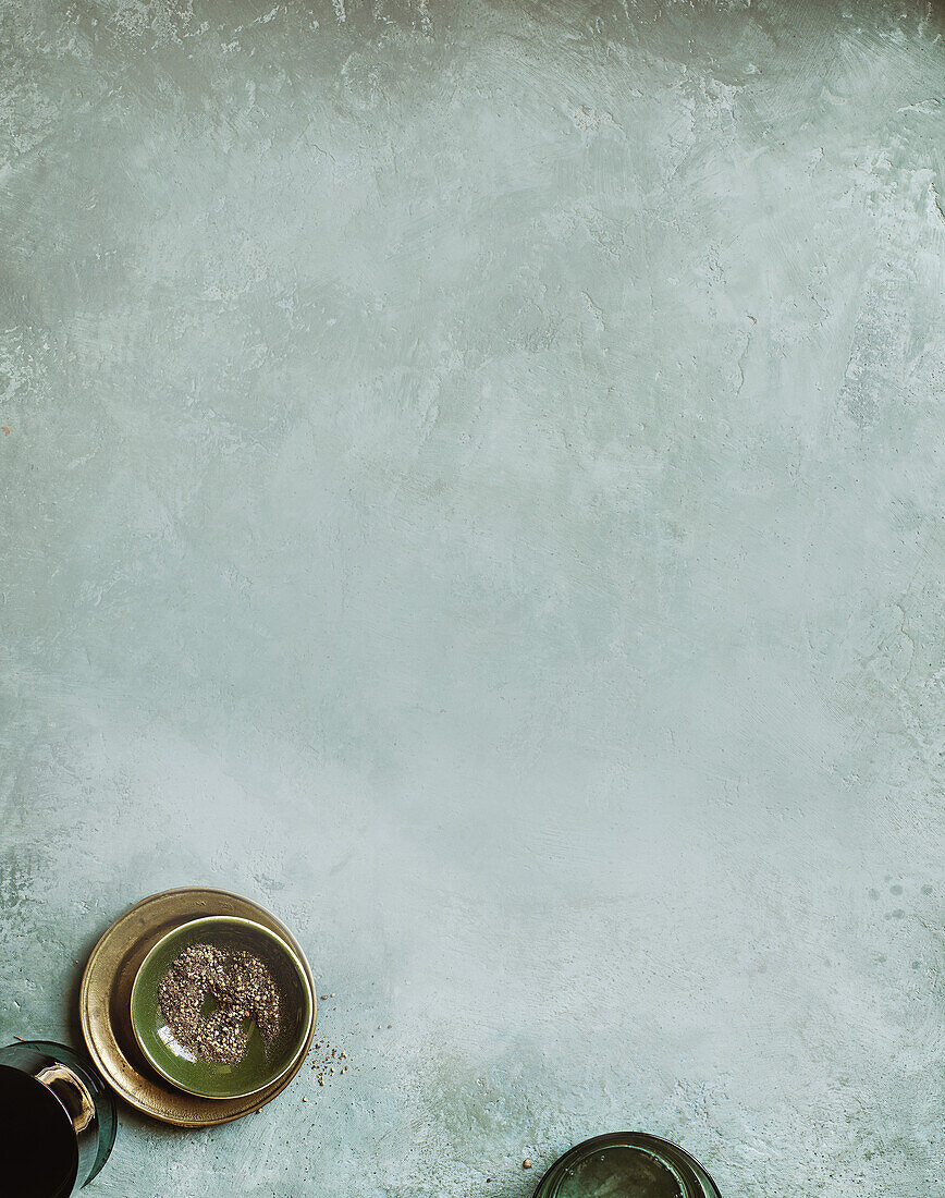 Concrete background with a bowl of crushed pepper