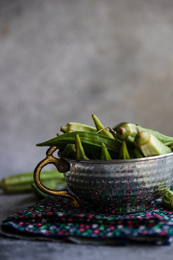 Frische Okra-Schoten in Metallschale