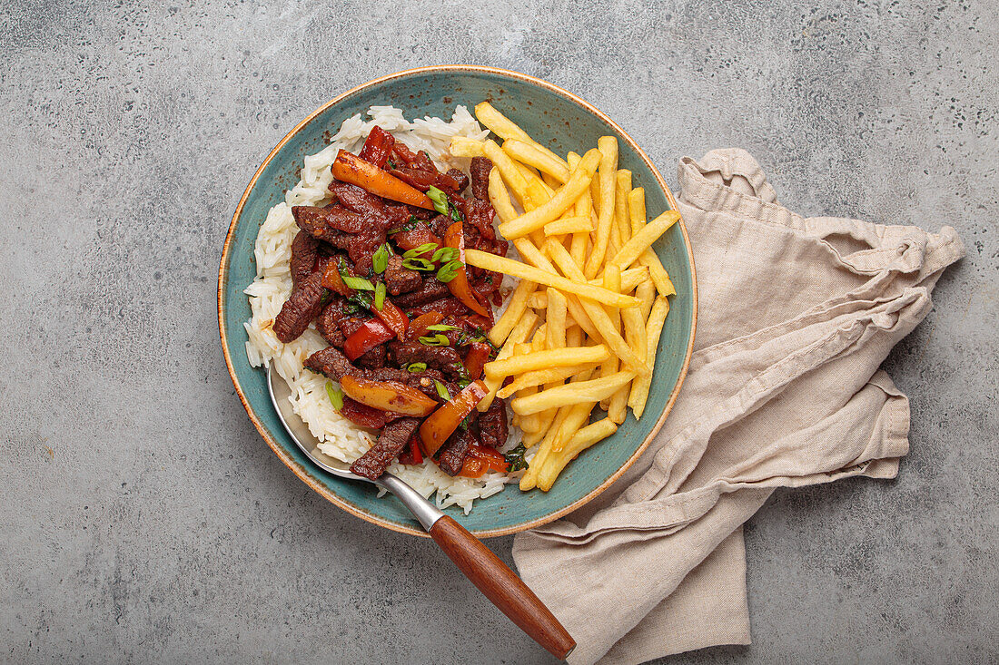 Peruanisches "Lomo Saltado" mit Rindfleisch, Pommes, Reis und Gemüse