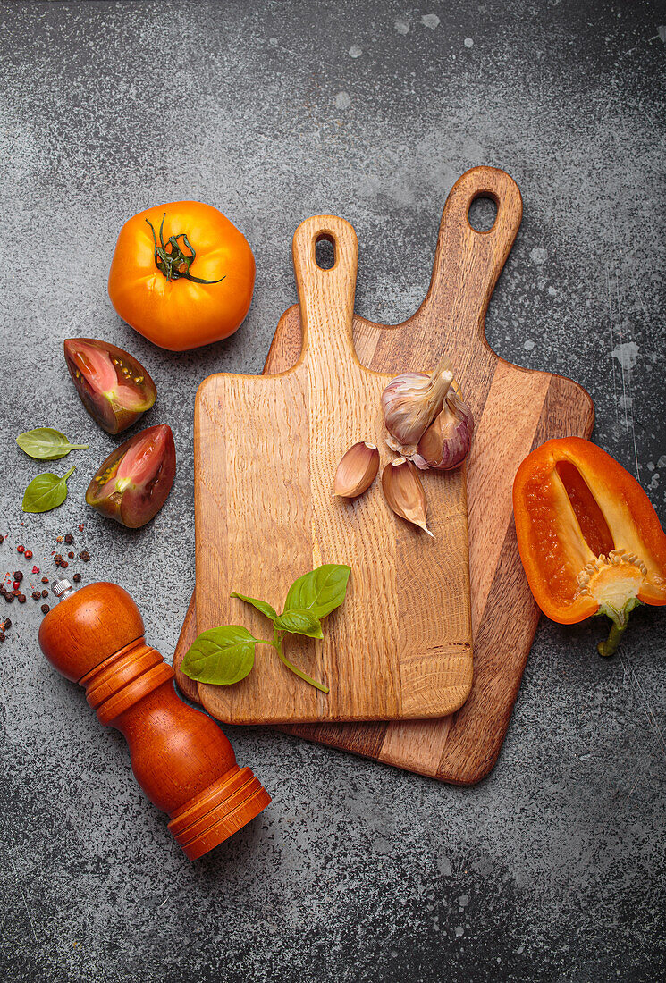 Stillleben mit Tomaten, Paprika und Knoblauch auf Holzbrettern