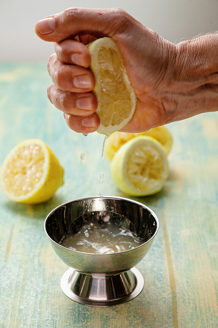 Hand squeezes fresh lemon