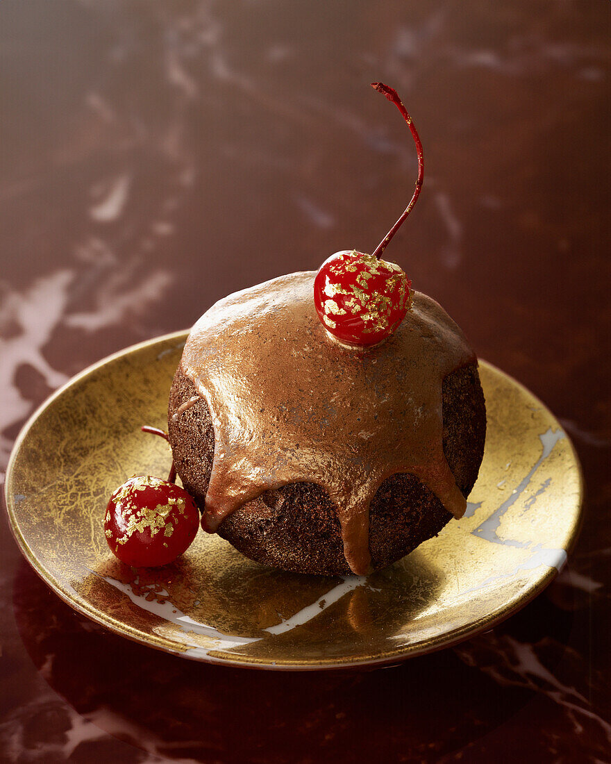 Boule de Noël with golden chocolate glaze and cherries