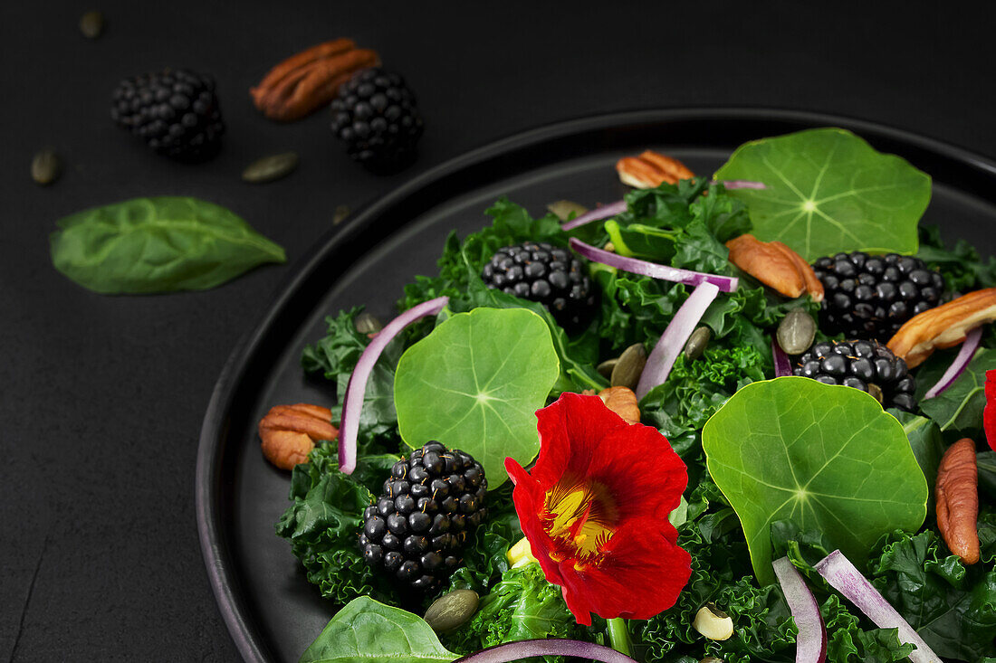 Kale salad with blackberries, nasturtium and pecans