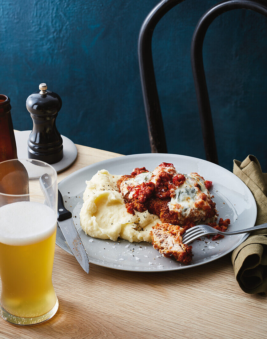 Pork neck schnitzel with mashed potatoes, bolognese and mozzarella