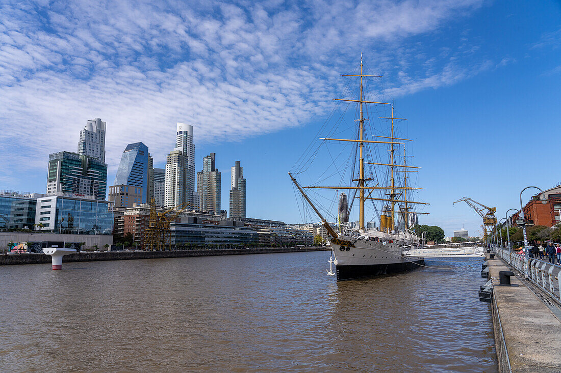 The ARA Presidente Sarmiento, a museum ship in Puerto Madero in Buenos Aires, Argentina. At left is the skyline of Puerto Madero with the Alvear Tower, the tallest building in Argentina.