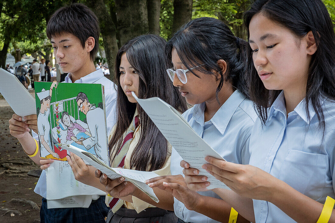 Studenten erklären Passanten die Geschichte von Sadako Sasaki, die den Papierkranich in ein Friedenssymbol verwandelte, am 6. August im Peace Memorial Park während des 79. Jahrestages, Hiroshima, Japan