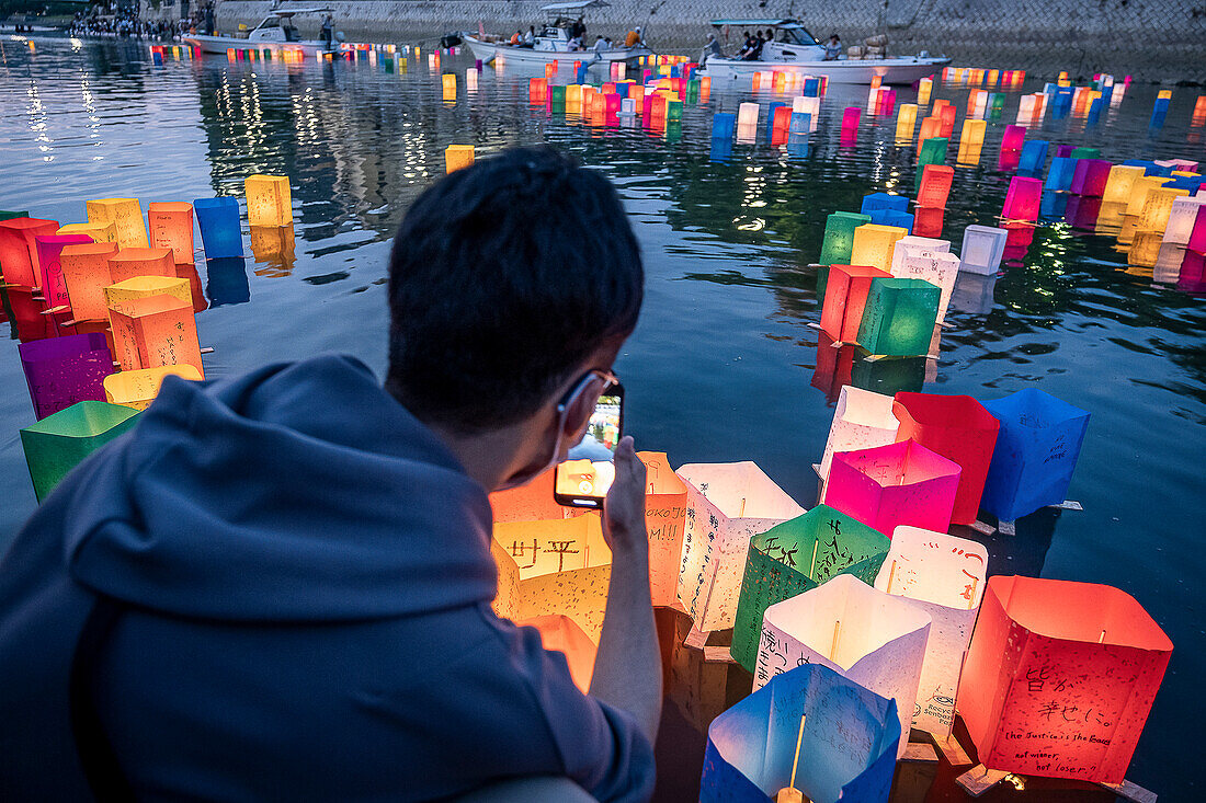 People float lanterns on the river, in front of Atomic Bomb Dome with floating lamps on Motoyasu-gawa River during Peace Memorial Ceremony every August 6 in Hiroshima, Japan