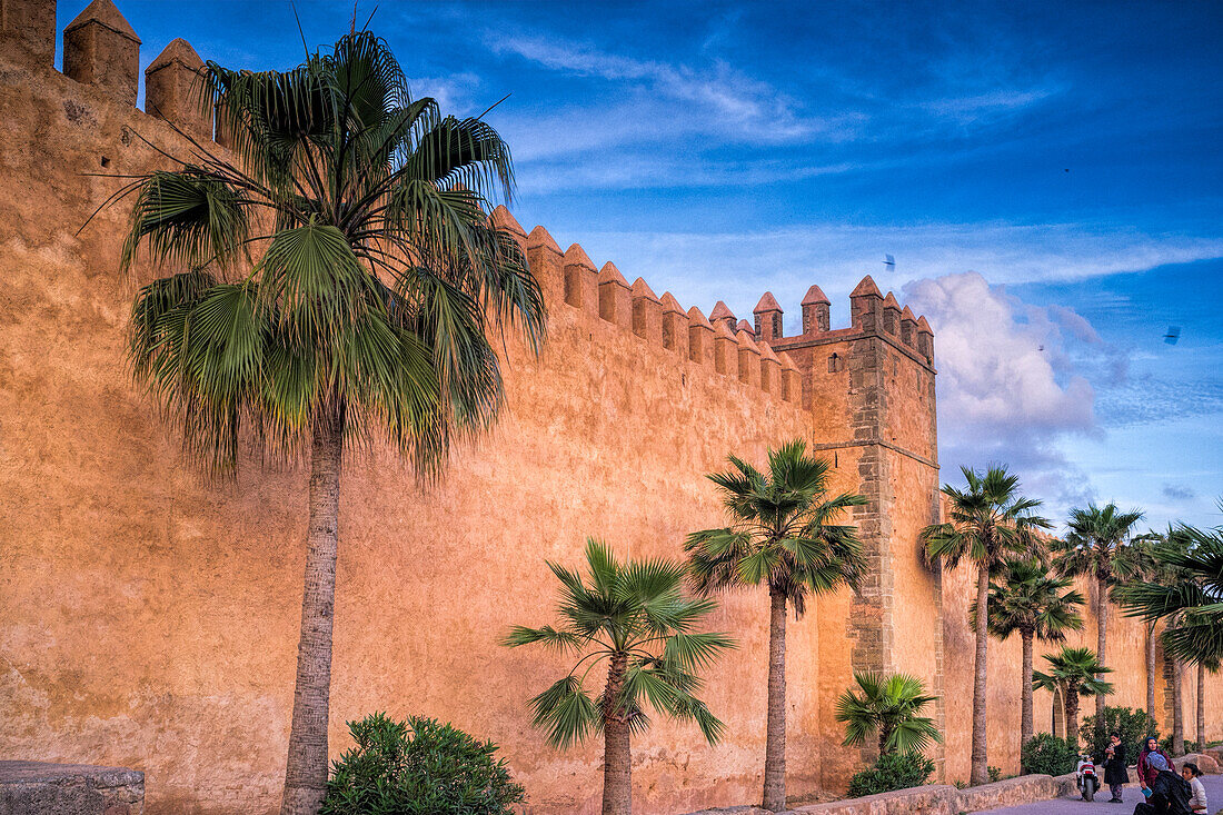 Rabat, Marokko, 24. April 2015, Die beeindruckenden Mauern der Kasbah der Udayas erheben sich in Rabat, Marokko, geschmückt mit Palmen unter einem leuchtenden Sonnenuntergangshimmel