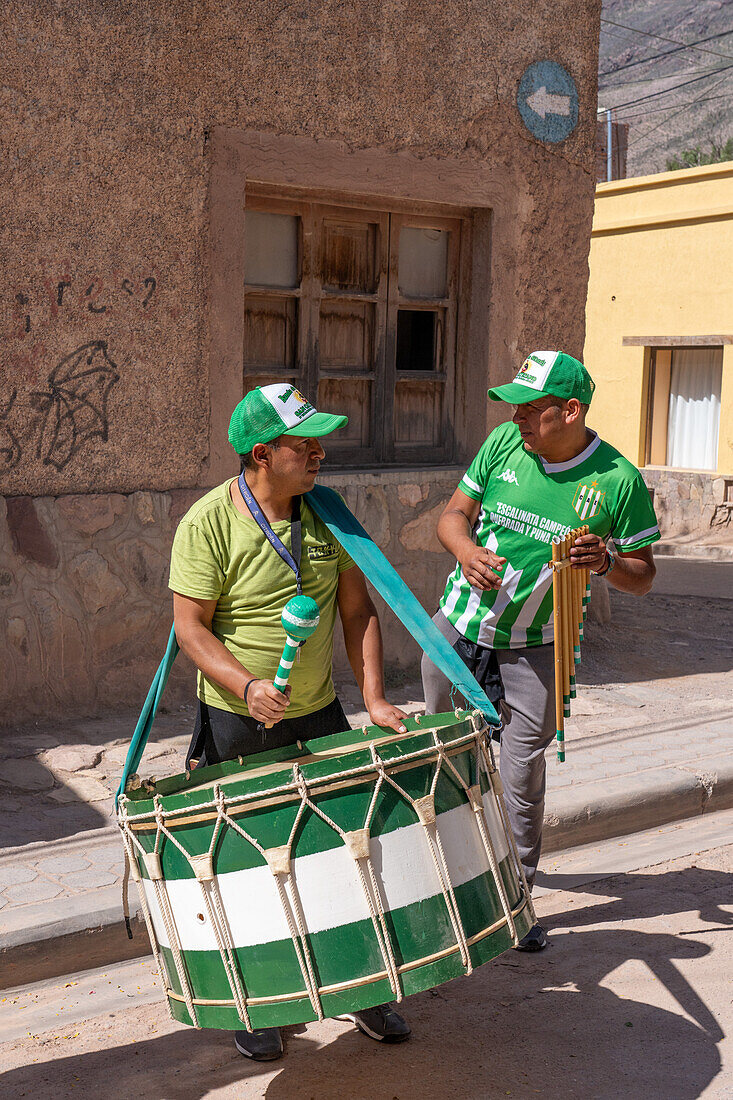 A drummer and siku panpiper prepares for a religious procession in front of the church in Tilcara, Argentina.