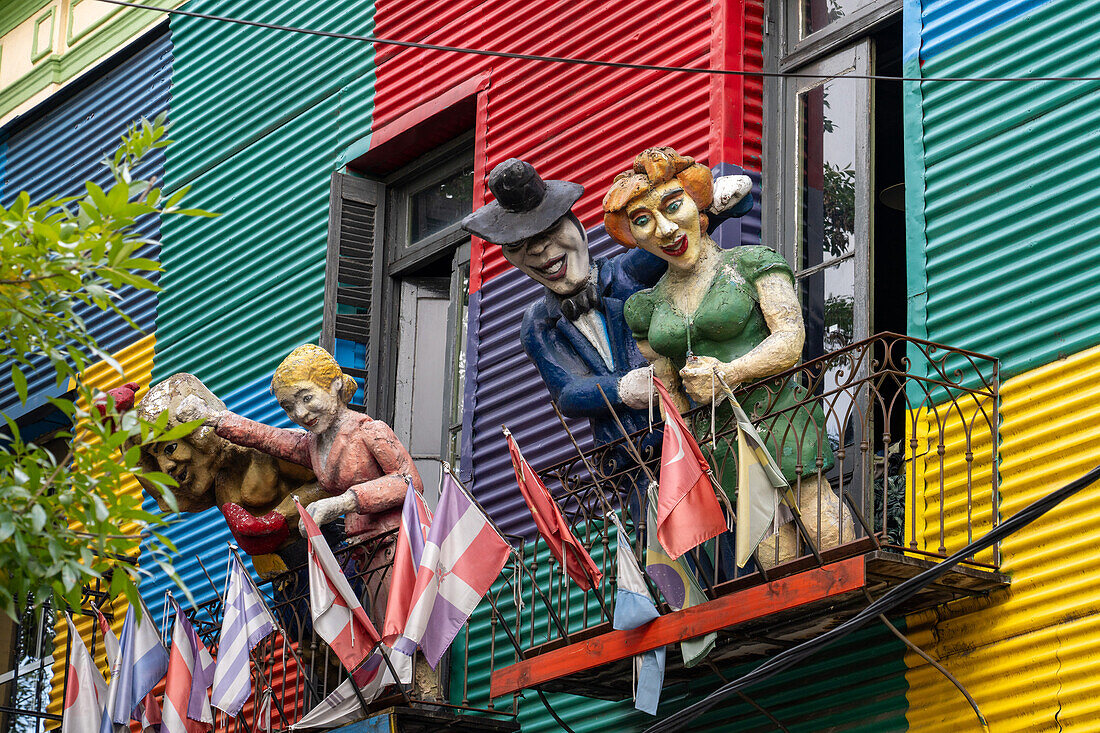 Caricature statues of people on balconies on a colorfully-painted building in Caminito, La Boca, Buenos Aires, Argentina. Evita or Eva Peron is depicted at left.