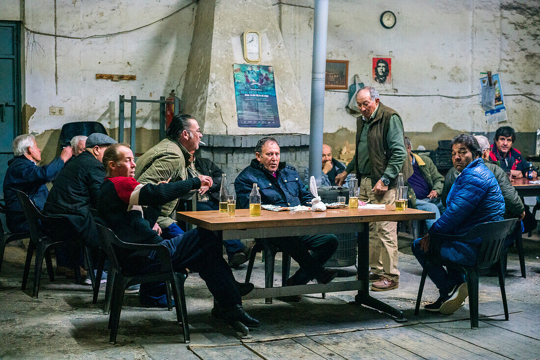 Pilas, Spain, Dec 20 2016, Group of men socializing and enjoying drinks in an old tavern setting in Pilas, Sevilla, Spain. Rustic ambiance reflects local culture and camaraderie.