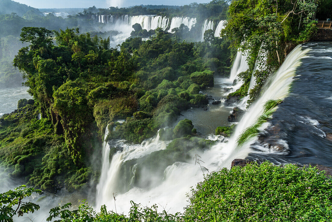 Nationalpark Iguazu-Fälle in Argentinien. Ein UNESCO-Welterbe. Die Bilder zeigen von links nach rechts die Wasserfälle San Martin, Mbigua, Bernabe Mendez, Adam und Eva und Bossetti. Ganz links in der Ferne sind die Santa-Maria-Fälle auf der brasilianischen Seite mit der Nebelfahne der Teufelskehl-Fälle zu sehen