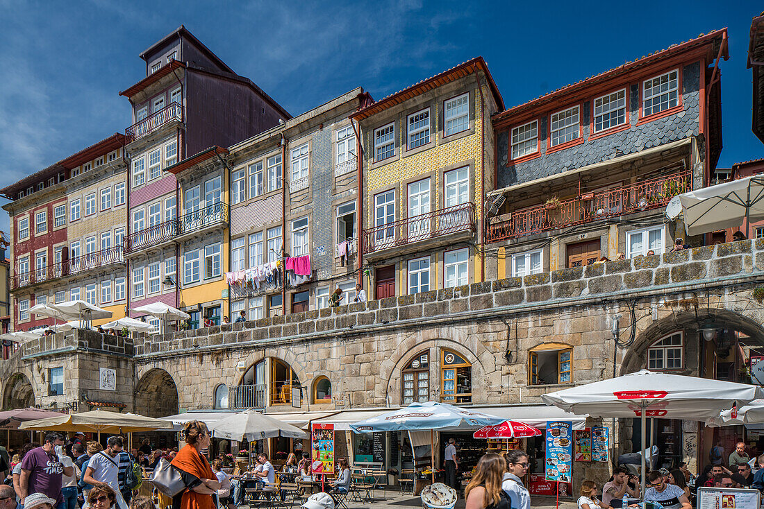 Porto, Portugal, Apr 15 2017, Vibrant street scene at Cais da Ribera in Porto, Portugal. People enjoy outdoor cafes and unique architecture under a clear blue sky, capturing the lively atmosphere.