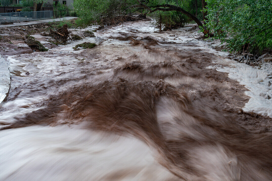 Langsame Verschlusszeit zur Glättung des turbulenten Wassers einer Sturzflut nach einem Sommerregen in Moab, Utah