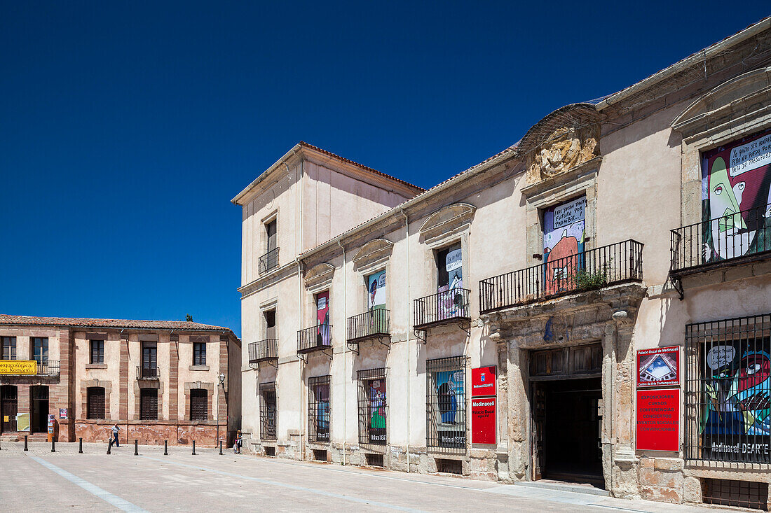 The Ducal Palace stands prominently in the Main Square of Medinaceli, showcasing its historical architecture against a bright blue sky.