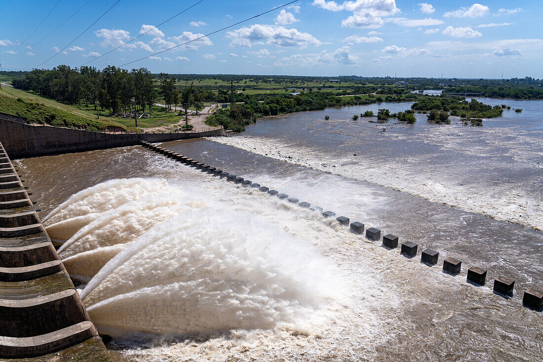 Plumes of water jet from the spillway of the Rio Hondo Dam at Termas de Rio Hondo in Argentina. At right is the Tara Inti Natural Reserve, including the small islands.