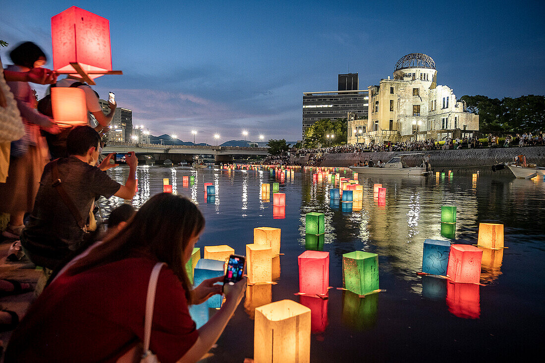 People float lanterns on the river, in front of Atomic Bomb Dome with floating lamps on Motoyasu-gawa River during Peace Memorial Ceremony every August 6 in Hiroshima, Japan