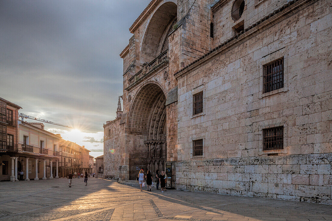 The grand Cathedral facade in El Burgo de Osma glows beautifully during sunset, illuminating the stone architecture and surrounding streets.