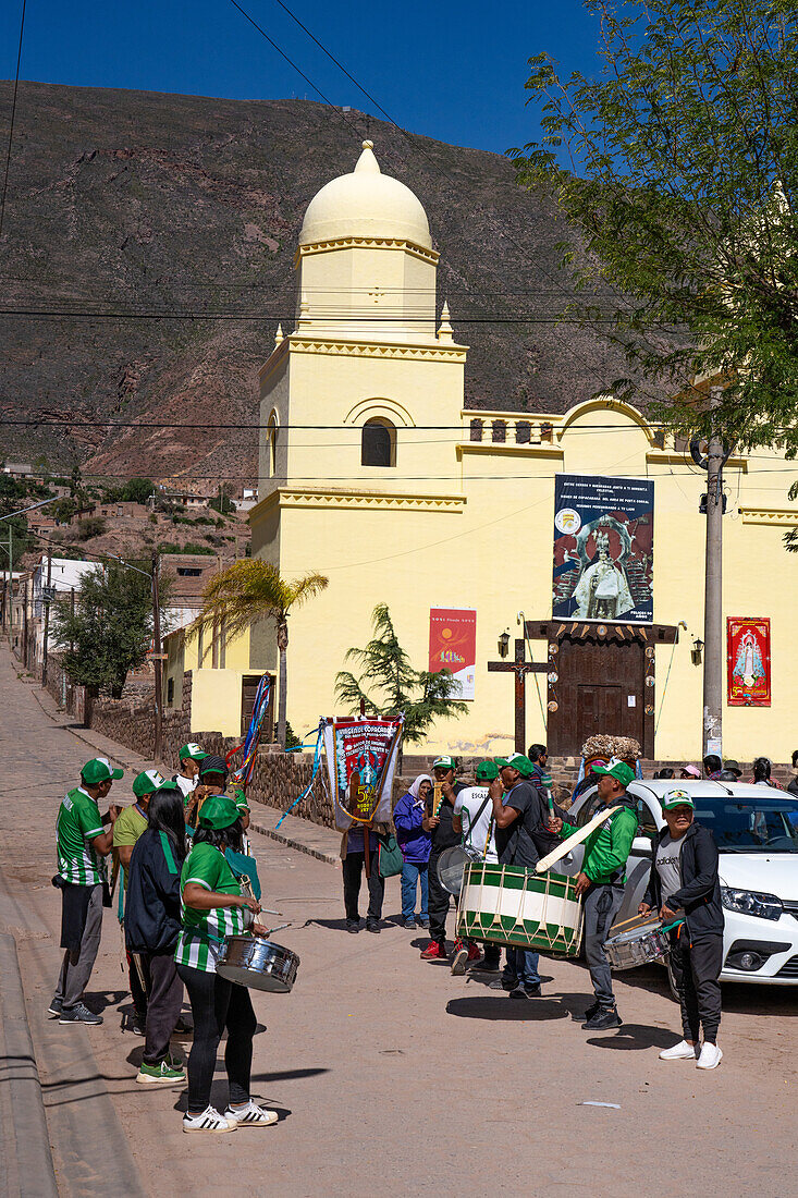 Eine Band mit Trommeln und Siku-Panflöten bereitet sich auf eine religiöse Prozession vor der Kirche in Tilcara, Argentinien, vor