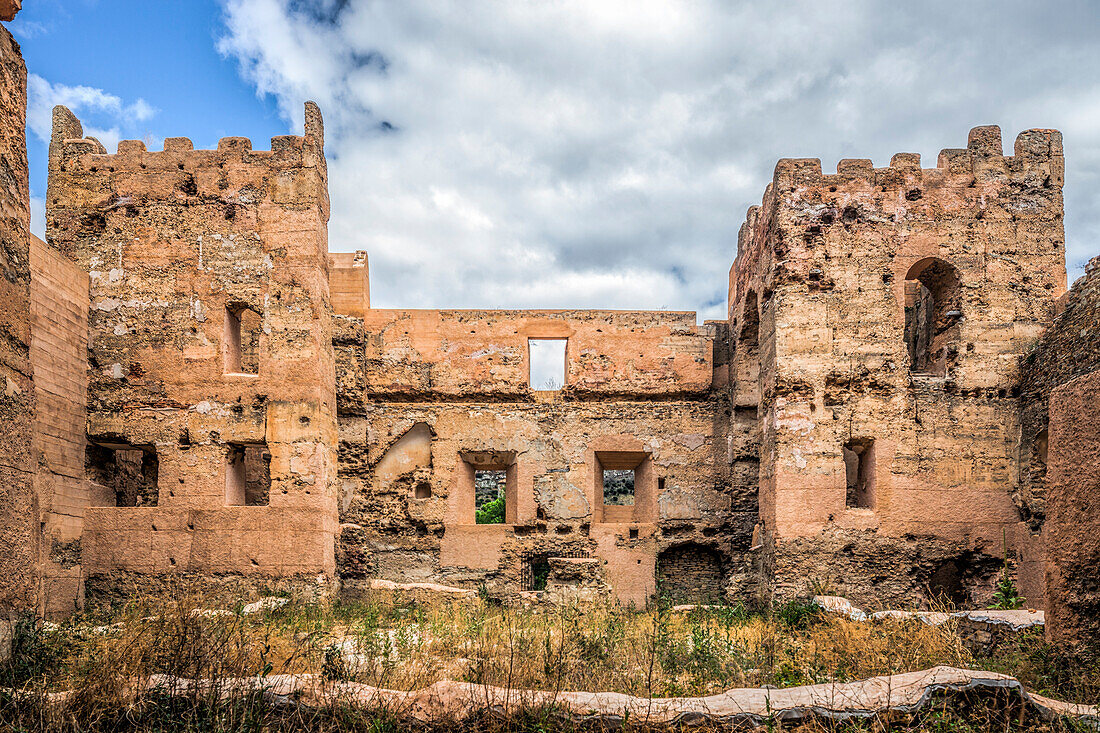 Die alten Ruinen der Burg Yanguas stehen inmitten von üppigem Gras unter einem dramatischen Himmel in Soria, Spanien, und laden zur Erkundung und zum Nachdenken ein