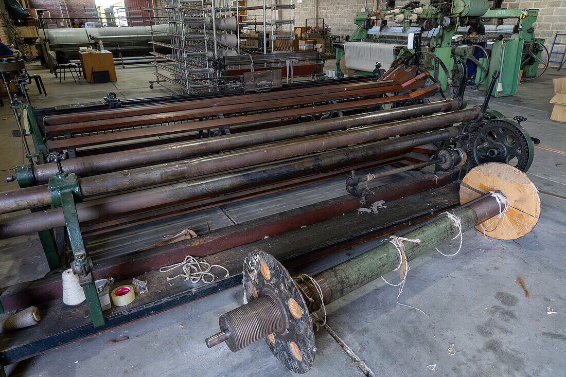 Eine Maschine zum Aufwickeln des Garns auf die sehr große Spule vor der Hilandería Warmi, einer Weberei in Palpalá, Argentinien. Die Webmaschinen der Weberei verwenden diese großen Spulen für das Grundfarbengarn