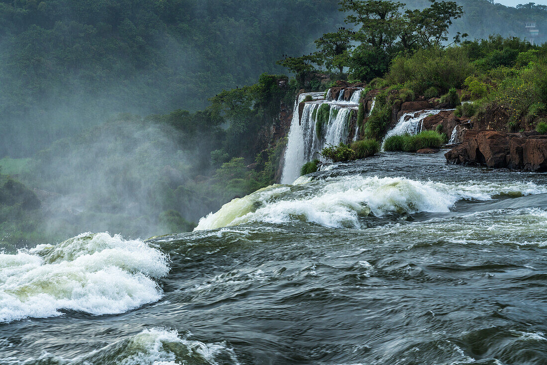 The Iguazu River flowing over the precipice of the San Martin Waterfall in Iguazu Falls National Park in Argentina. Salto Escondido or the Hidden Waterfall is just visible as well. A UNESCO World Heritage Site.