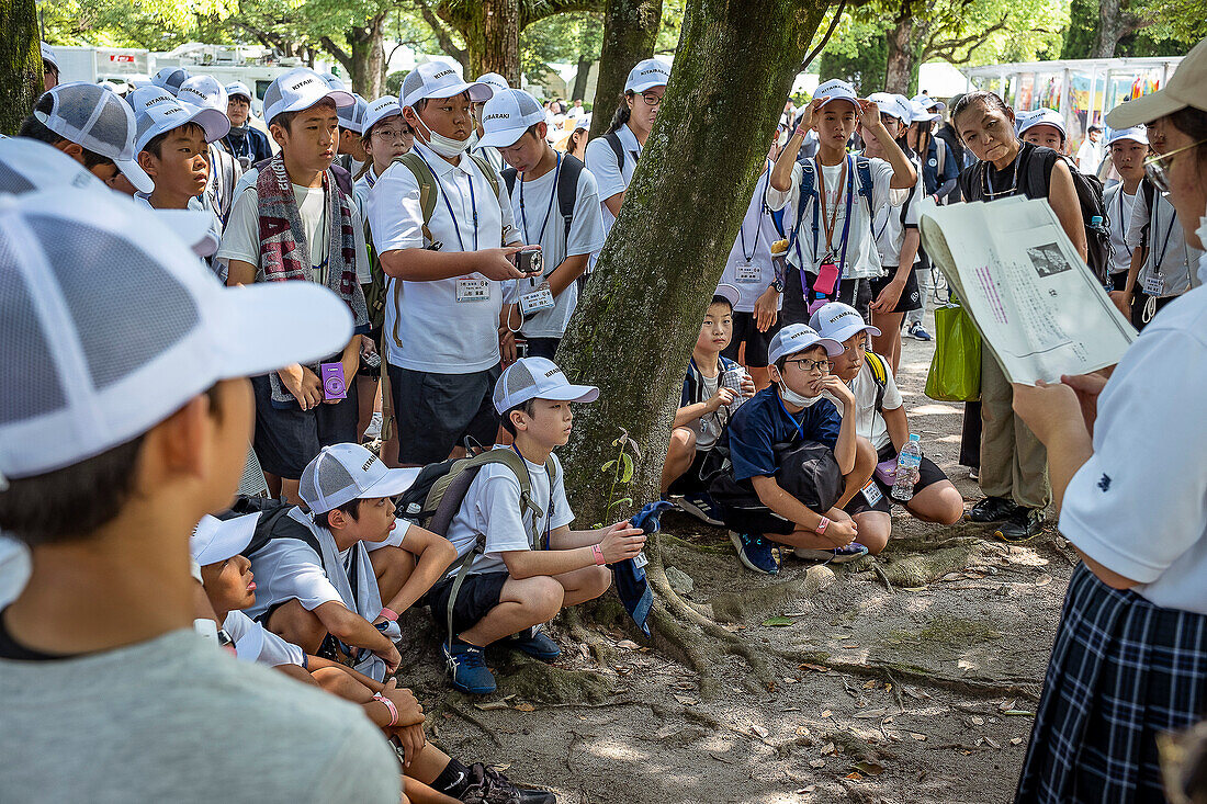 Studenten erklären Passanten die Geschichte von Sadako Sasaki, die den Papierkranich in ein Friedenssymbol verwandelt hat, am 6. August im Peace Memorial Park, anlässlich des 79