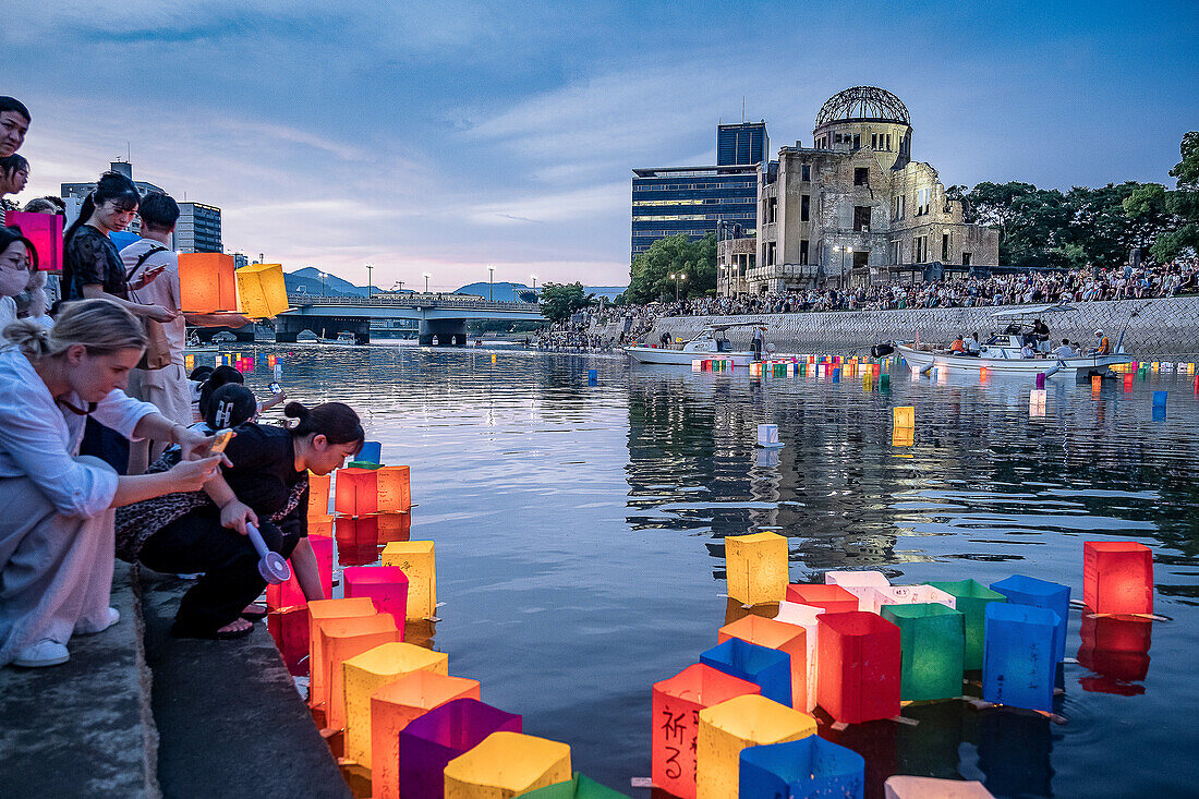 People float lanterns on the river, in front of Atomic Bomb Dome with floating lamps on Motoyasu-gawa River during Peace Memorial Ceremony every August 6 in Hiroshima, Japan