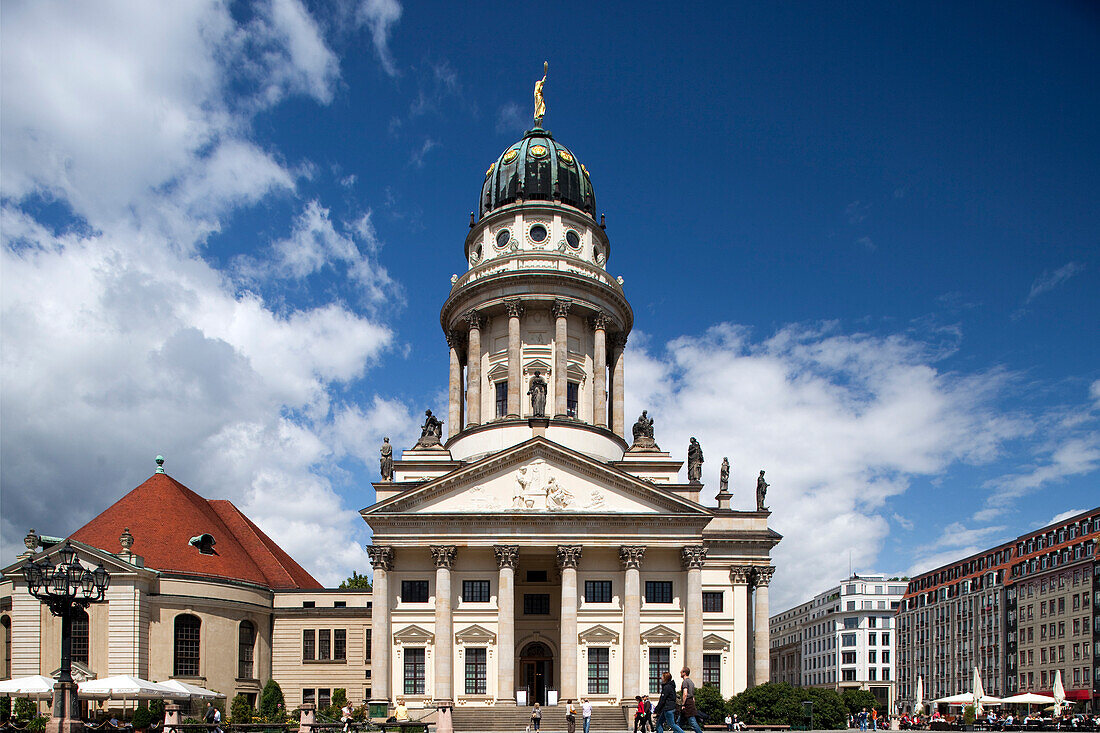 Französische Dom stands majestically on Gendarmenmarkt, showcasing its elegant design against a vibrant blue sky in Berlin.