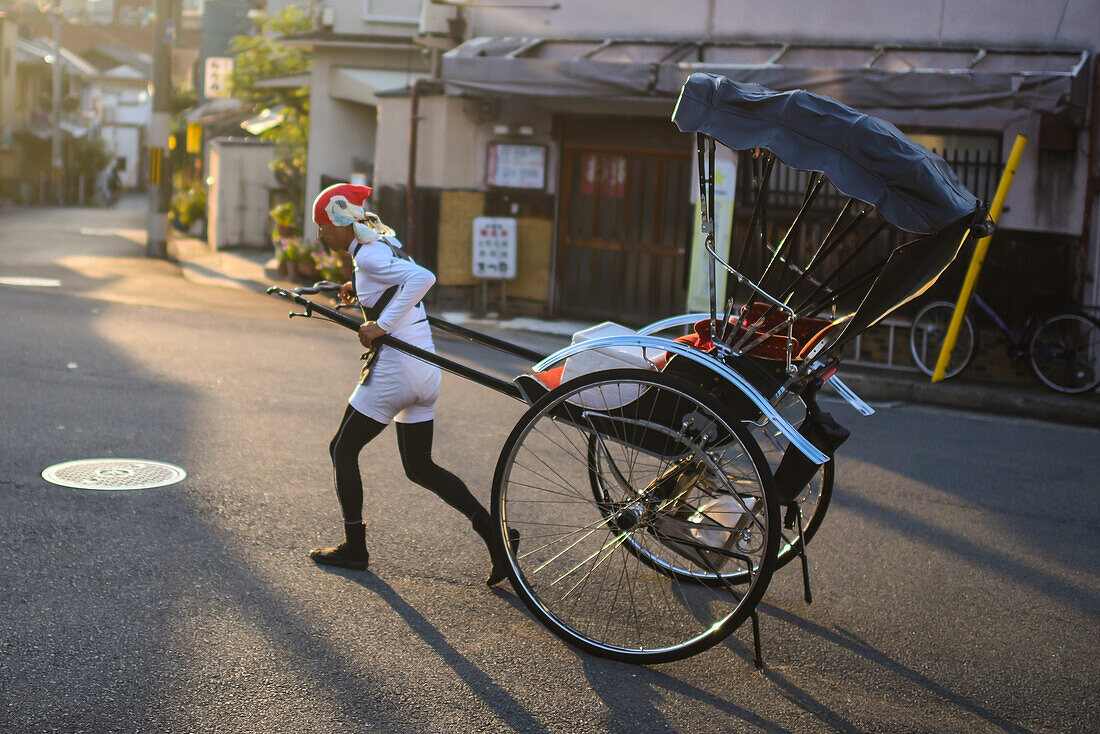 Rickshaw man at sunset in Kyoto, Japan