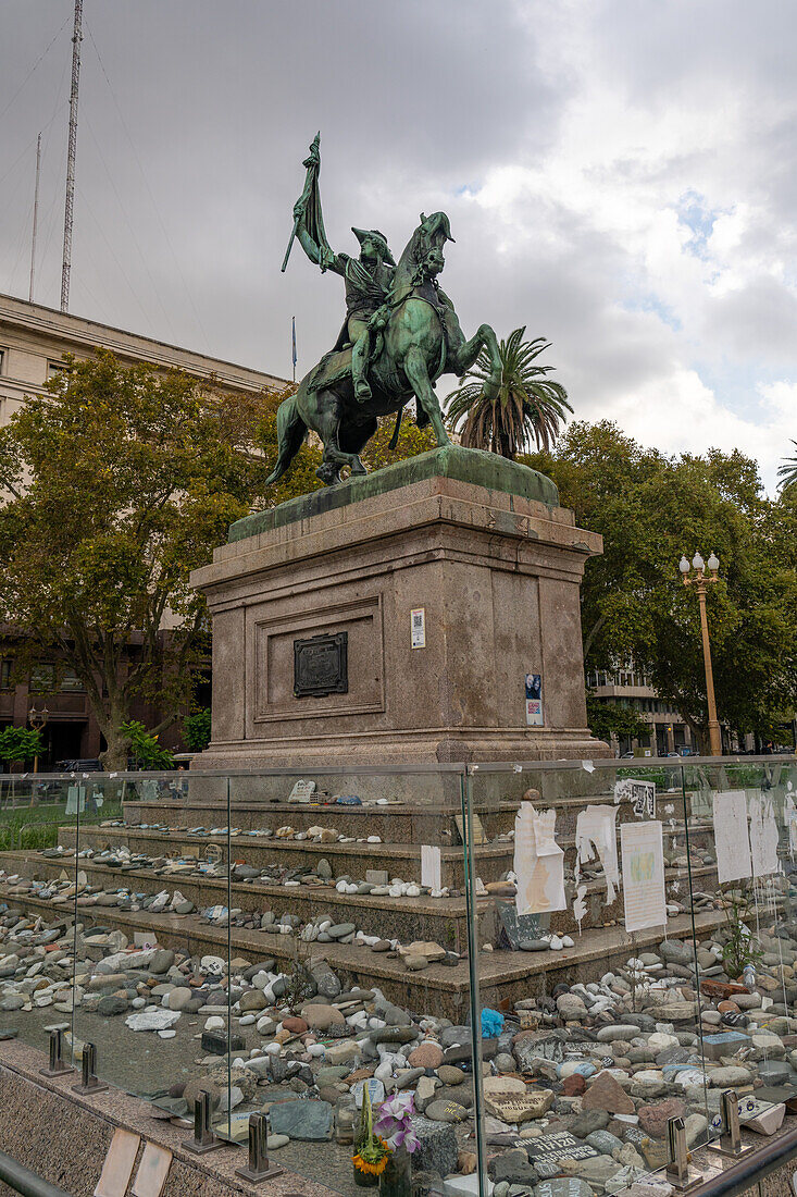 Equestrian statue of General Manuel Belgrano in the Plaza de Mayo in Buenos Aires, Argentina. Stones around the base of the statue represent victims who died of Covid-19.