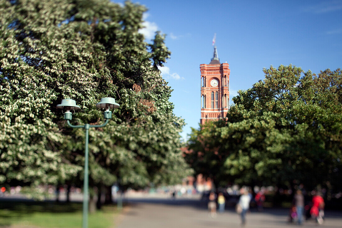 Das ikonische Rathaus erhebt sich über den Bäumen im Park des Marx-Engels-Forums und zeigt die atemberaubende Architektur und das lebendige Grün Berlins