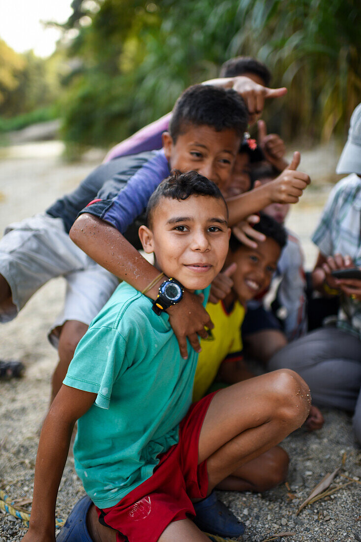 Group of playful local kids having fun with a foreigner woman, Santa Marta, Colombia